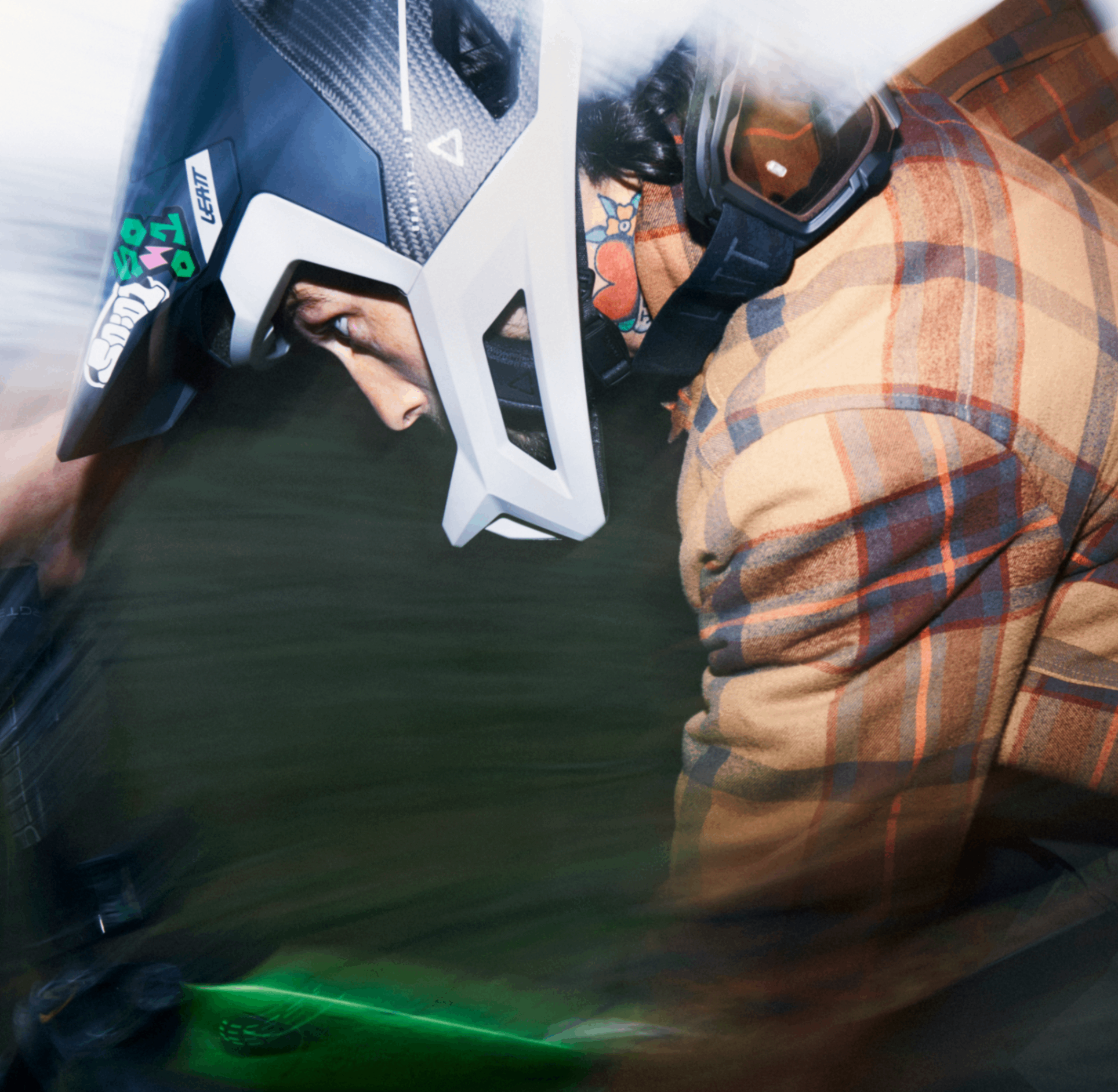 Person wearing a plaid jacket and helmet, possibly in a racing or extreme sports setting.