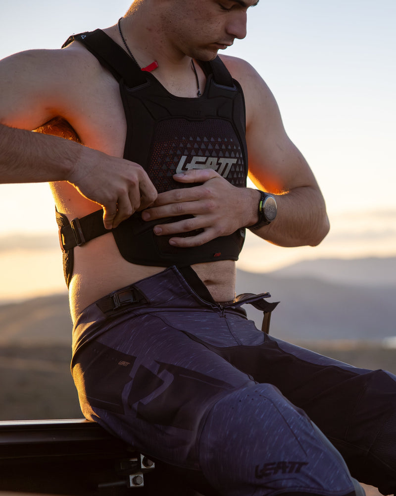 Person wearing a tactical vest with mountains in the background