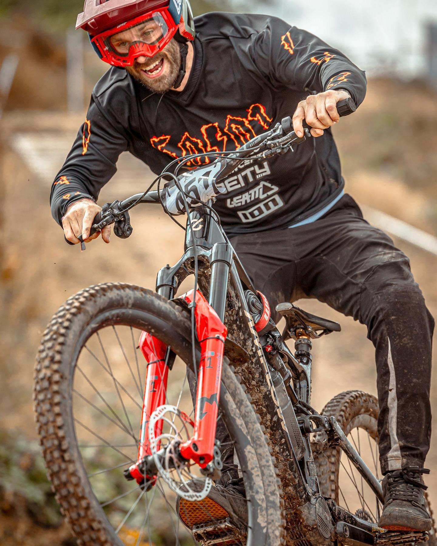 Biker in action on a mountain bike with visible brand logos.