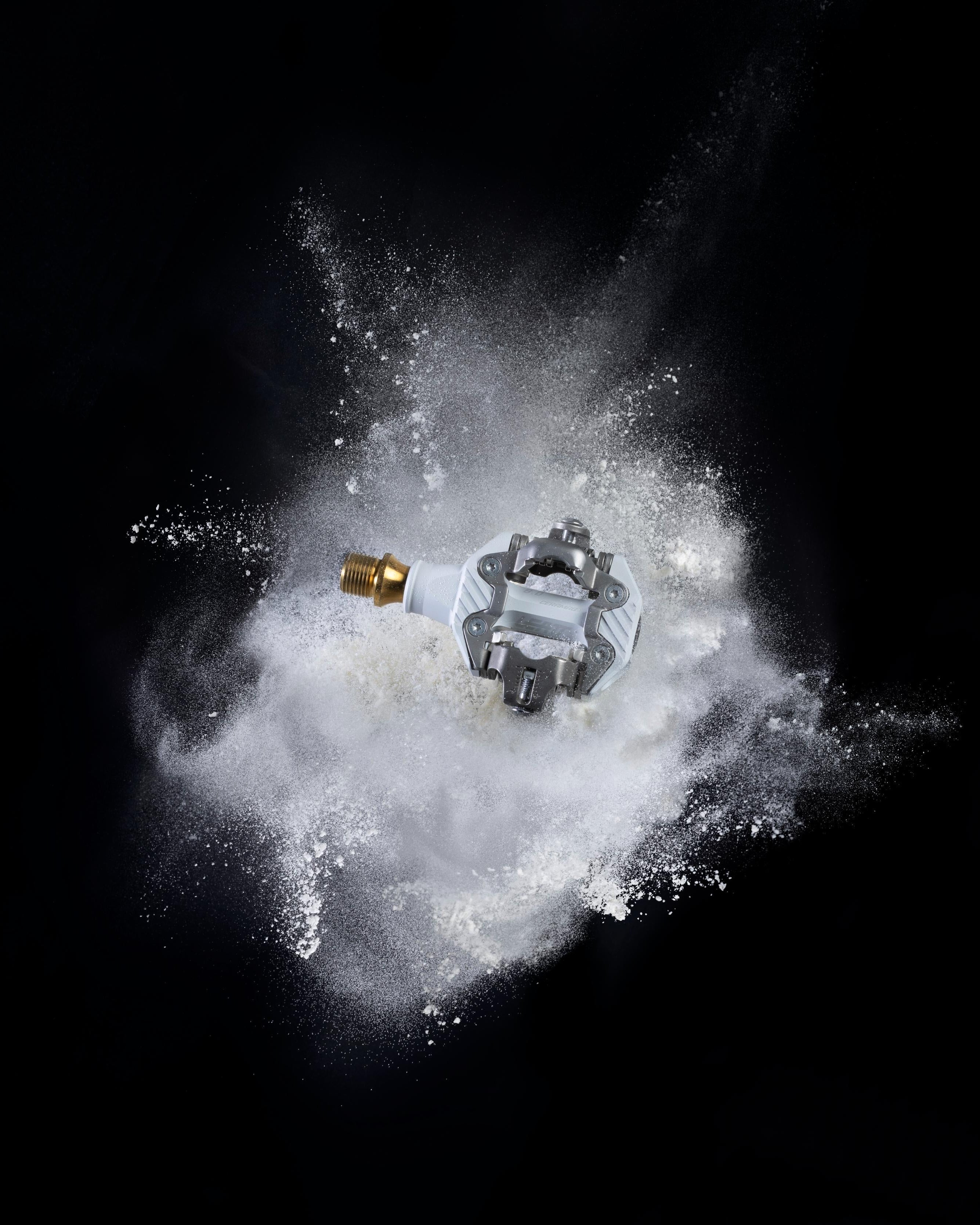 Clip pedal on a cloud of dust against a black background
