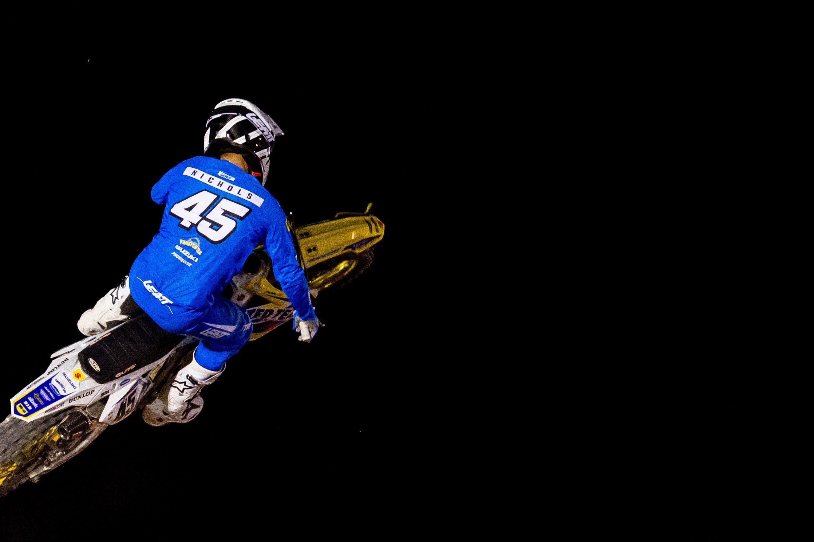 Motorcyclist in mid-air performing a stunt against a black background