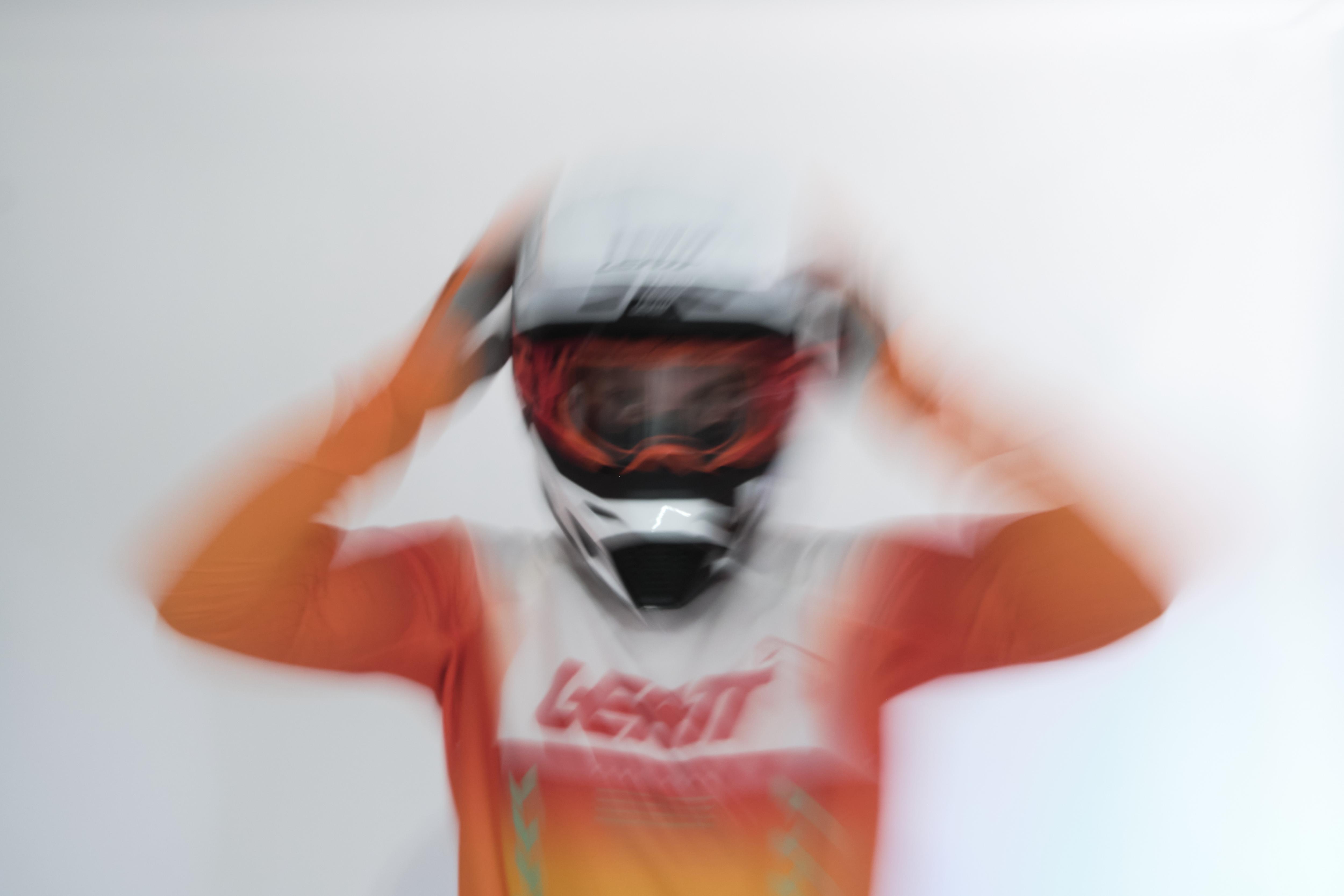 Person wearing a helmet and racing suit with Leatt branding on a white background