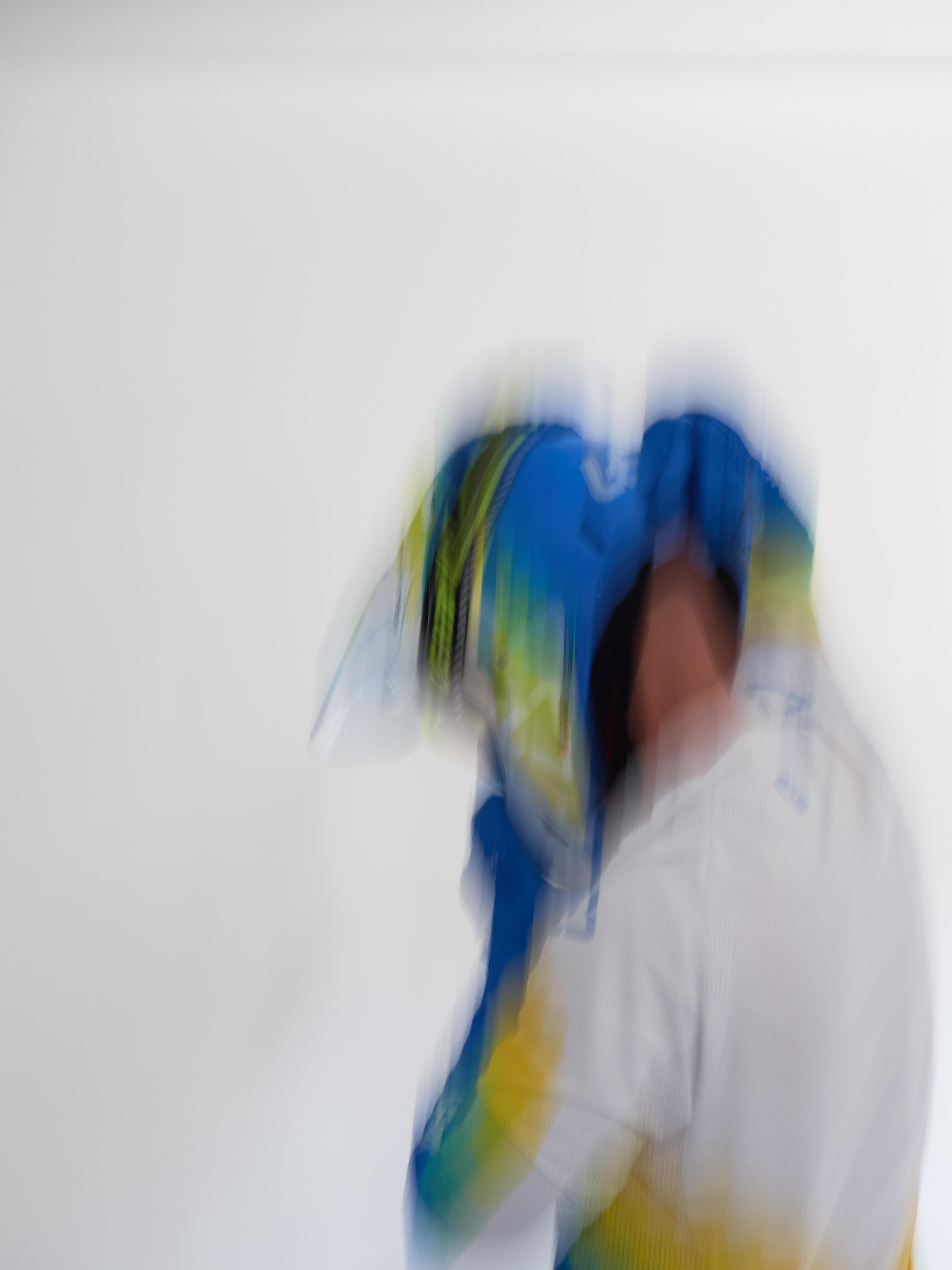 Person wearing a colorful racing suit and helmet with a white background