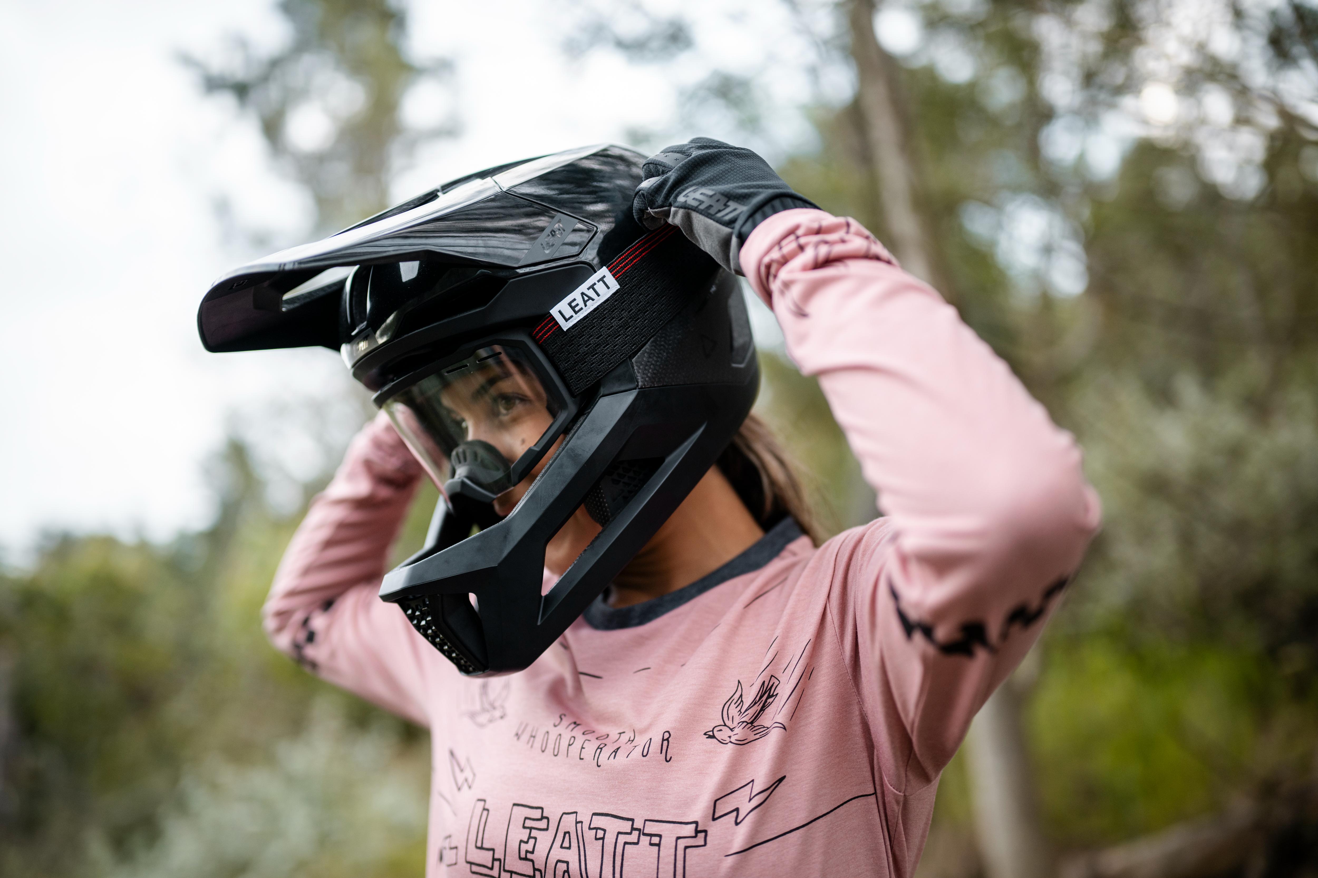 Person wearing a black helmet with a blurred natural background